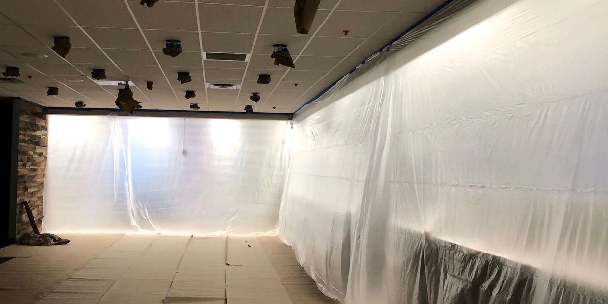 Masked off for ceiling tiles and grid to be painted with black dry fall.