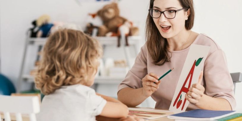Woman teaching a child using flashcards.