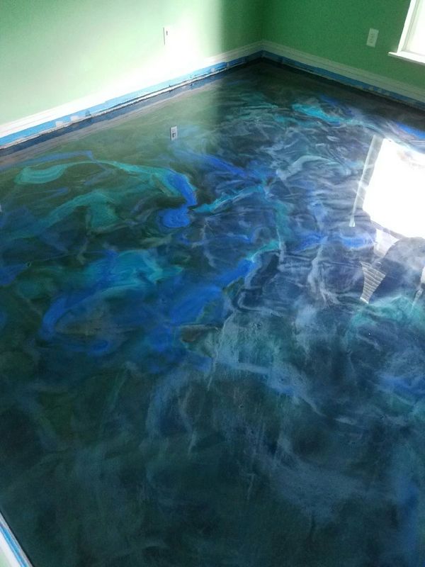 Room with a glossy, swirling blue epoxy floor and green walls.