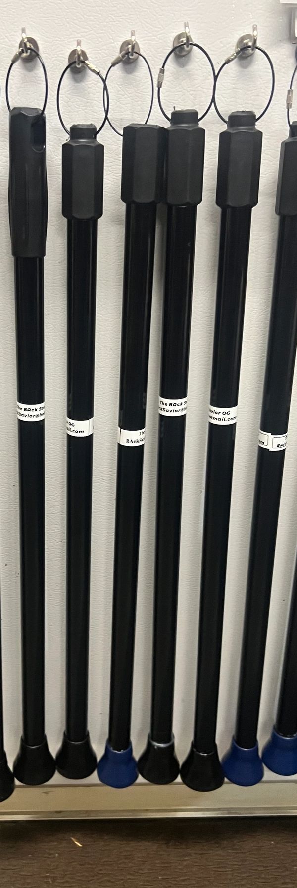 Black walking canes hanging on hooks.