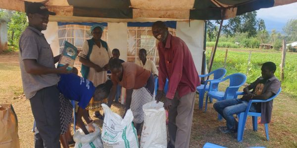 People distributing farming supplies outdoors.