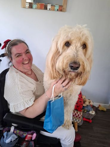 Woman smiling with large fluffy dog.