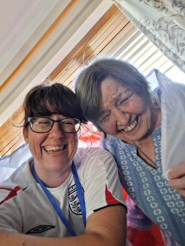 Two women smiling happily indoors.
