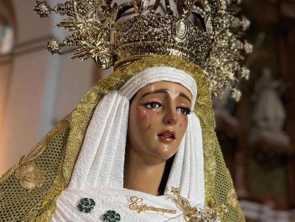 Religious statue of a sorrowful Virgin Mary with a golden crown and white veil.