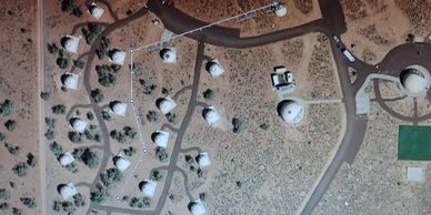 Aerial view of a cluster of white dome-shaped buildings connected by roads.