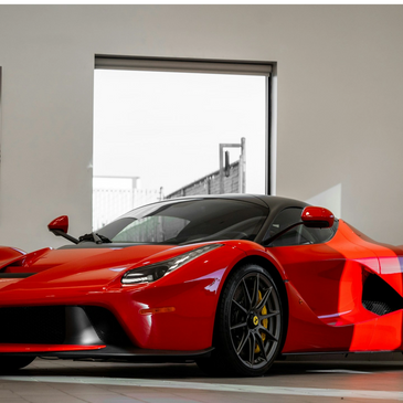 Beautiful Red Ferrari in a room in front of a window.