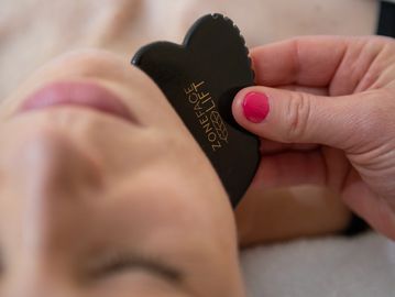 gua sha facial tool being used on face