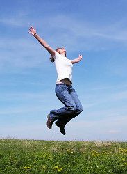 Photo of woman leaping above grass into the sky