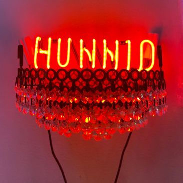 Red Neon Hunnid sitting on top a crystal crown