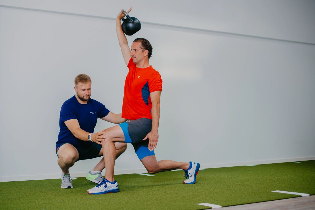 Paul Hützen korrigiert einen Kunden im Personal Training bei einem Ausfallschritt mit Kettlebell