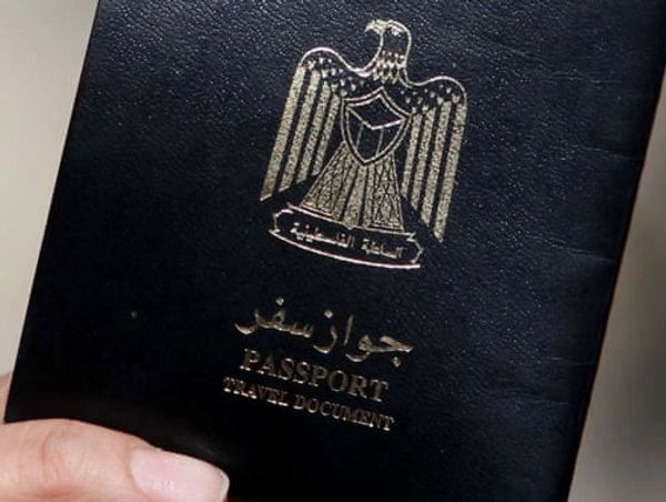 Close-up of a black passport with Arabic text and an eagle emblem.