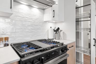 Modern kitchen with a gas stove and organized utensils.