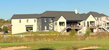 Spacious designer home with contrasting siding, multiple balconies, and scenic backdrop