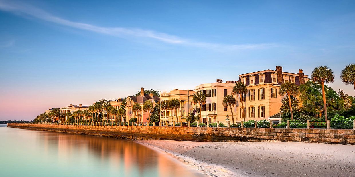 Historic waterfront mansions bathed in golden sunset light.