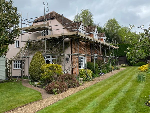 Plastering, applying stucco and painting the facade walls using scaffoldings