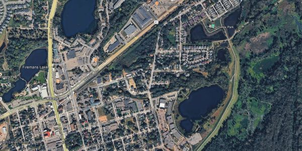 Aerial view of a suburban area with lakes and roads.