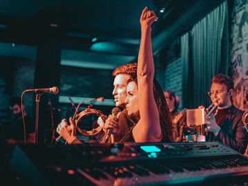 Musicians performing live on stage with instruments.