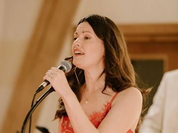 Woman singing into a microphone.