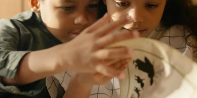 Two children intently reading a large book together.