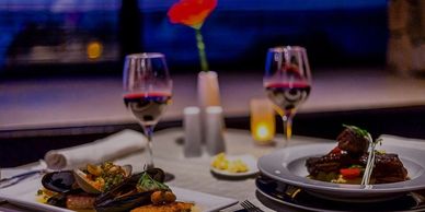 Elegant dinner setup with wine and gourmet dishes for two.