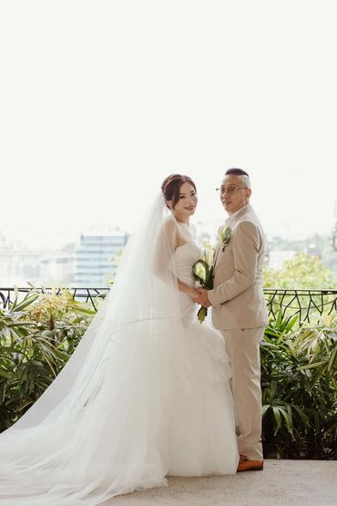 Bride and groom holding hands, smiling on their wedding day.