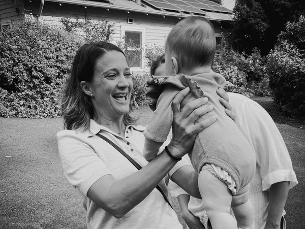 Midwife holding baby and smiling 