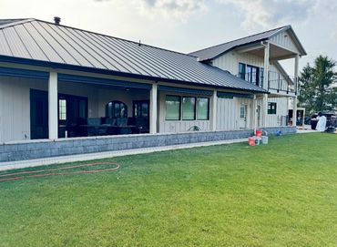Modern farmhouse with metal roof and stone retaining wall in Ridgefield, WA