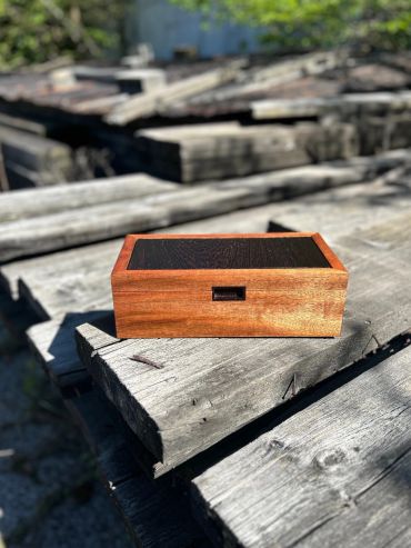 A small rectangular wooden box on weathered wooden planks.