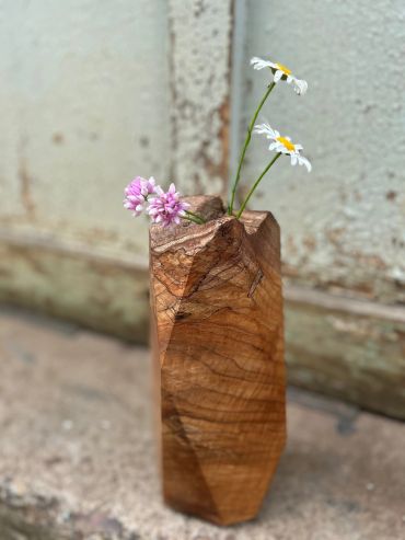 Wooden vase with two white daisies and a pink flower.
