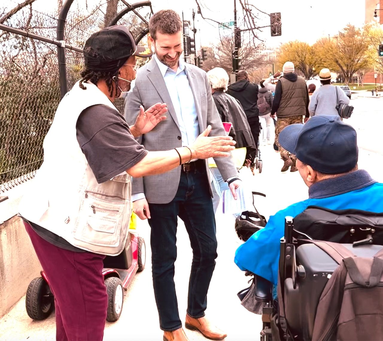 Council member Charles Allen, bike helmet in hand, tours the K St NW bike lane in April, 2022. Allen uses his position as head of the transportation committee to funnel millions to WABA.