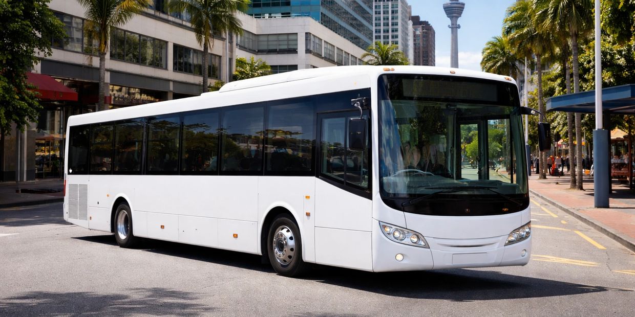 A white city bus driving on an urban street lined with palm trees.