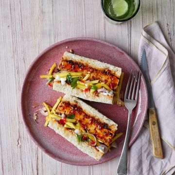 a pink plate with glazed tofu and mango salad sandwich