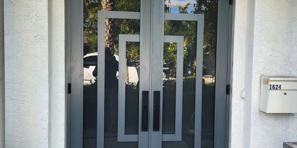 Modern double glass impact front doors with geometric design.