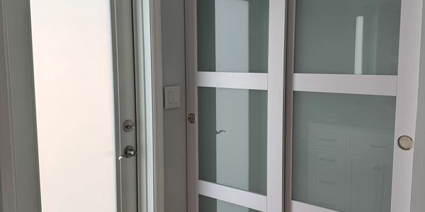 Frosted glass impact door and sliding closet doors.