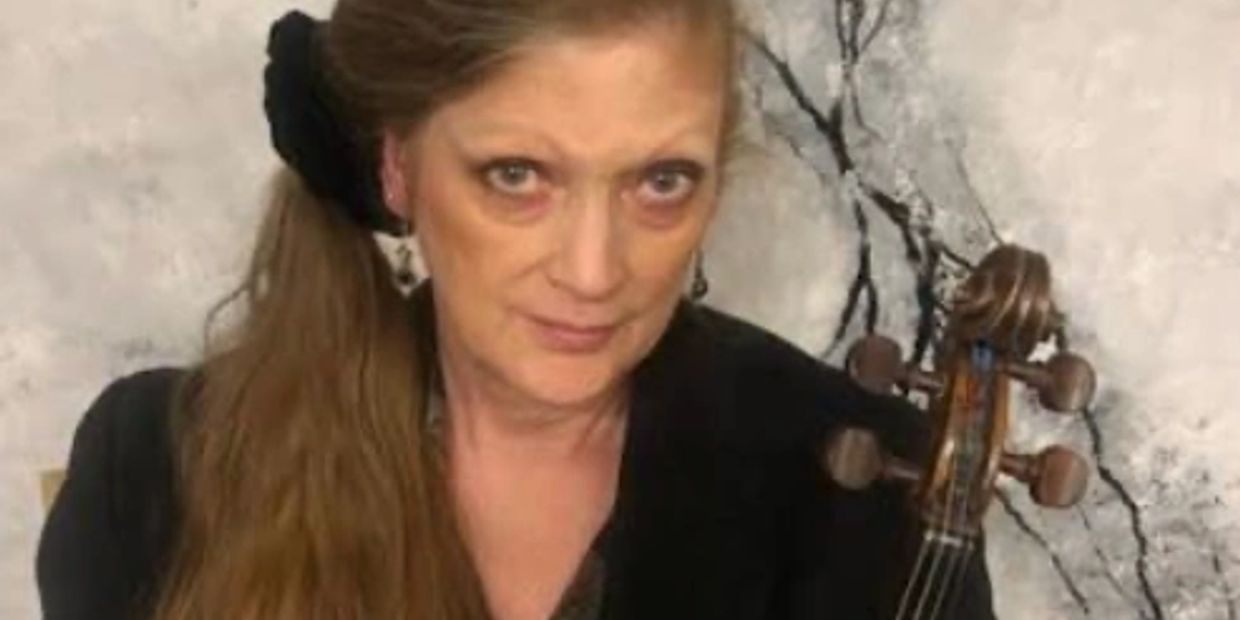 Woman with a violin against a marble-like background.