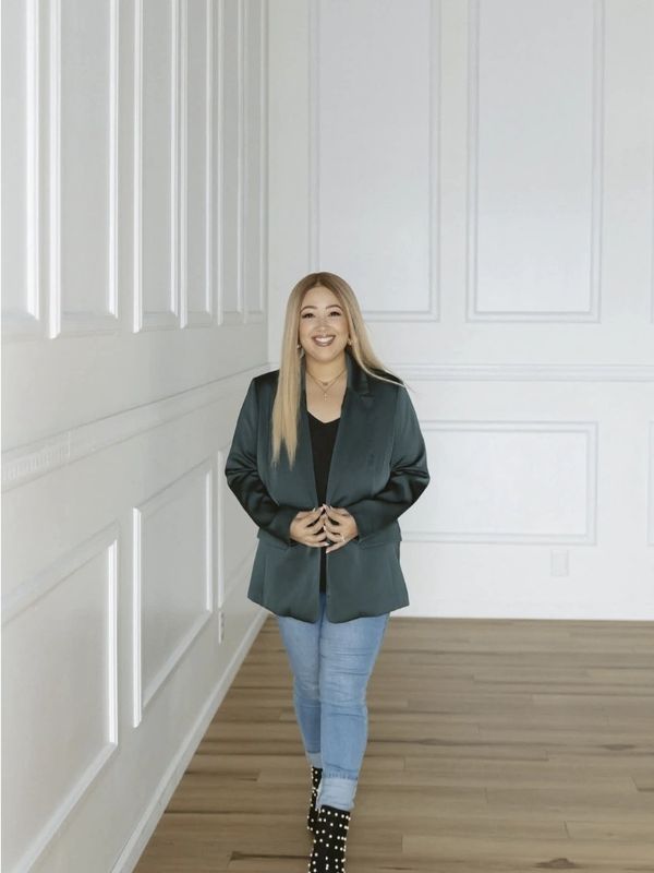Woman happily posing in a modern, minimalist room.