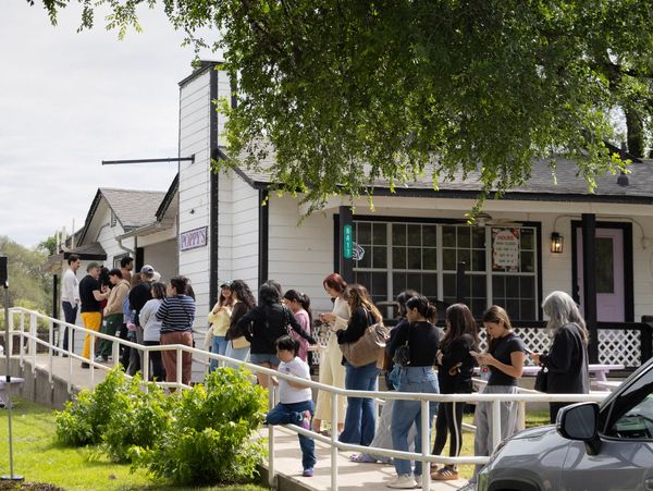 People standing in line outside a building.