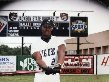 Baseball player from Jackson State University posing with bat.