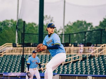 Young baseball pitcher preparing to throw a pitch on the field.
