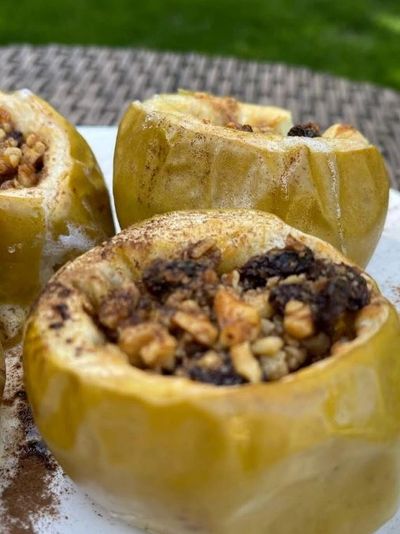Baked apples stuffed with nuts and raisins, sprinkled with cinnamon.