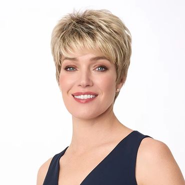 Smiling woman with short blonde hair in a navy blue sleeveless dress.