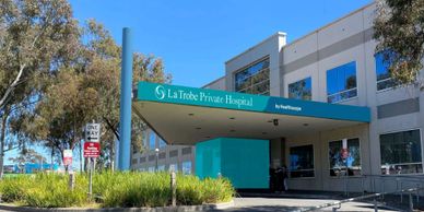 Entrance of La Trobe Private Hospital under a clear blue sky.