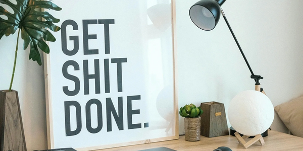 Desk with sign that says get shit done