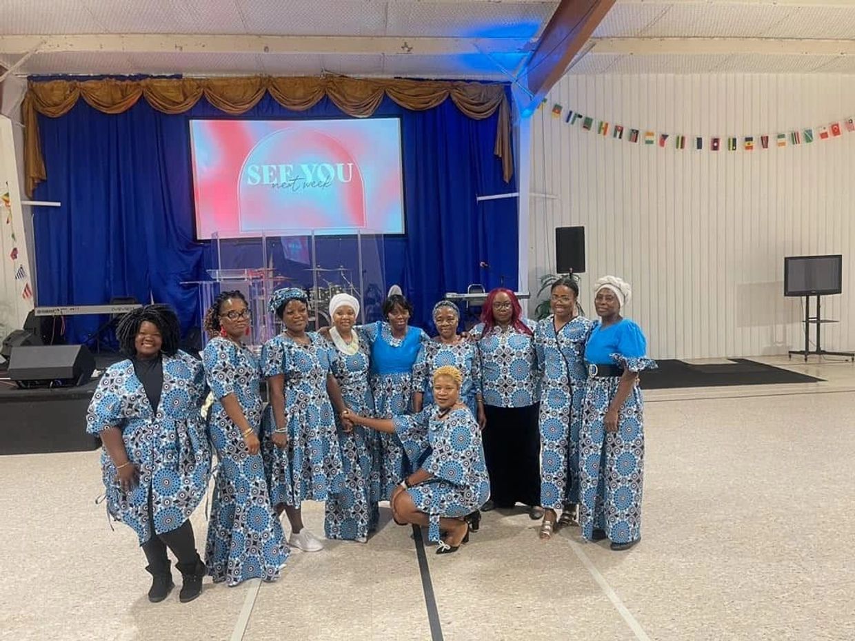 Group of women in matching blue patterned outfits posing indoors.