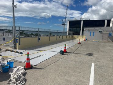 Construction work in a parking lot with cones and tools.