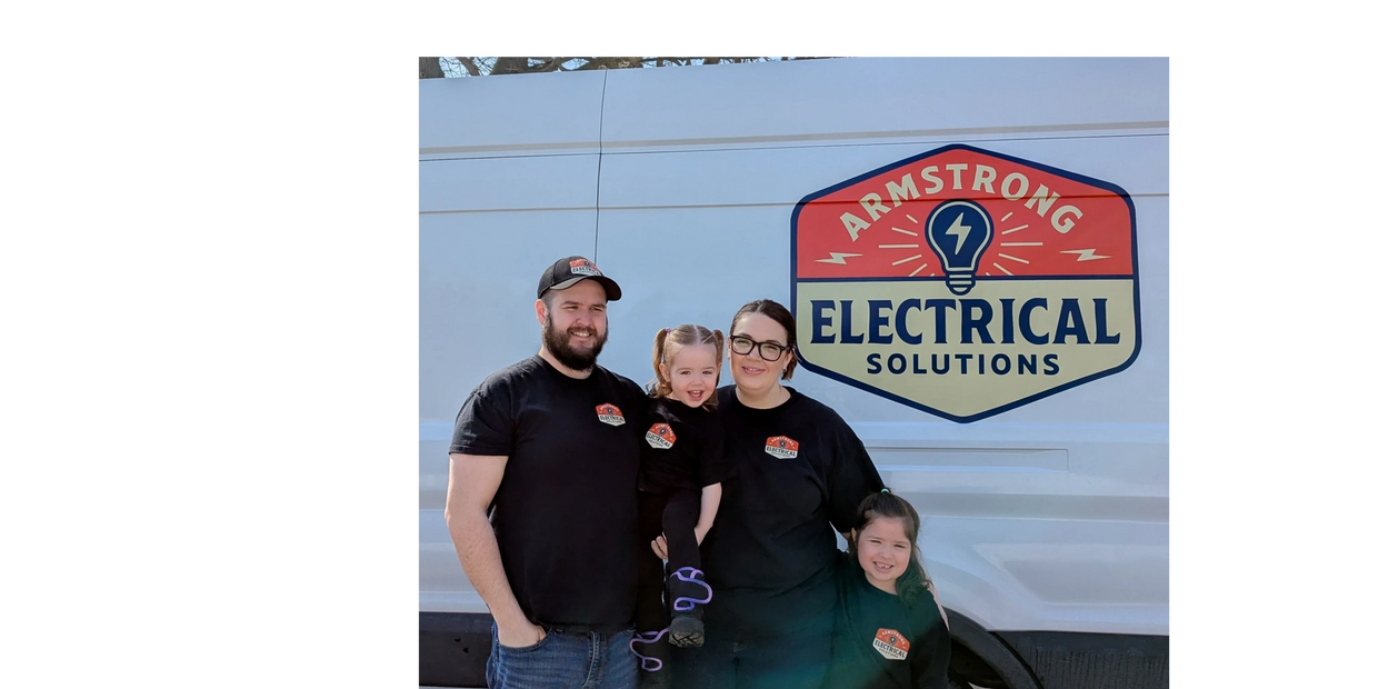 Family of four wearing matching shirts in front of an Armstrong Electrical Solutions van.
