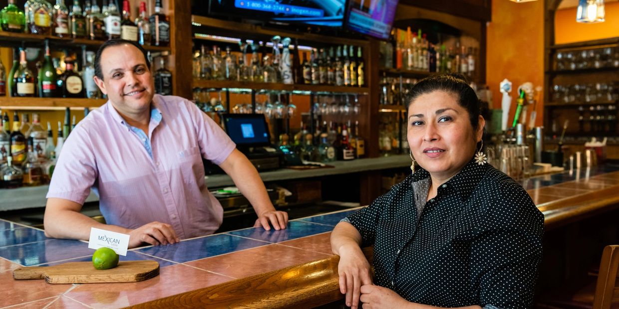 a man and a woman sitting at a bar
