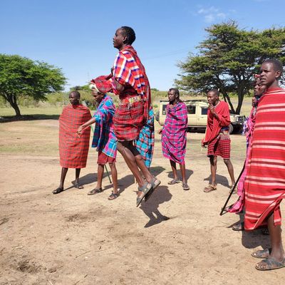 Group of Maasai men jumping and standing outdoors.