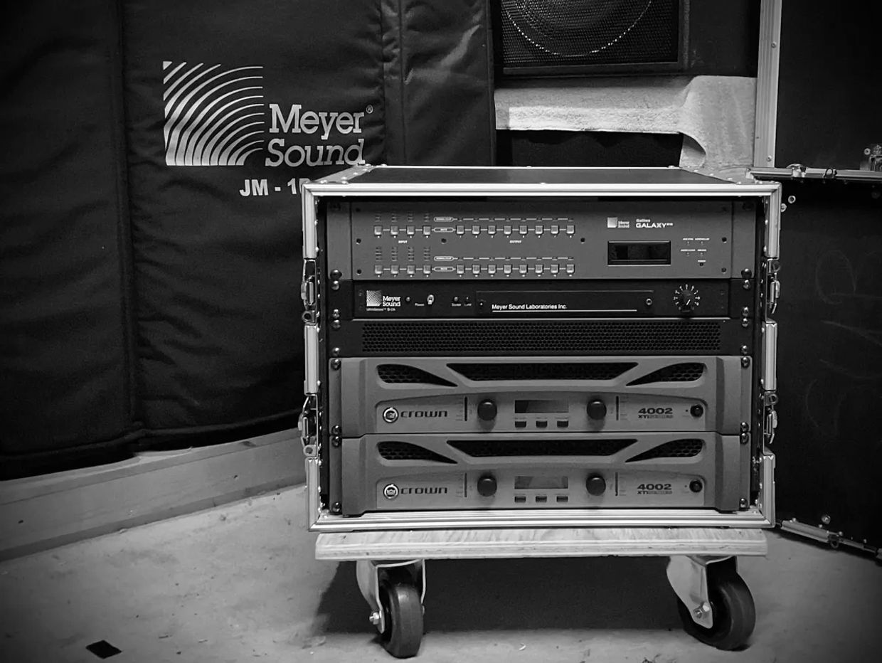 Professional audio equipment rack with Meyer Sound and Crown components.