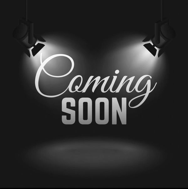 Stylish 'Coming Soon' text highlighted by spotlights on a dark background.